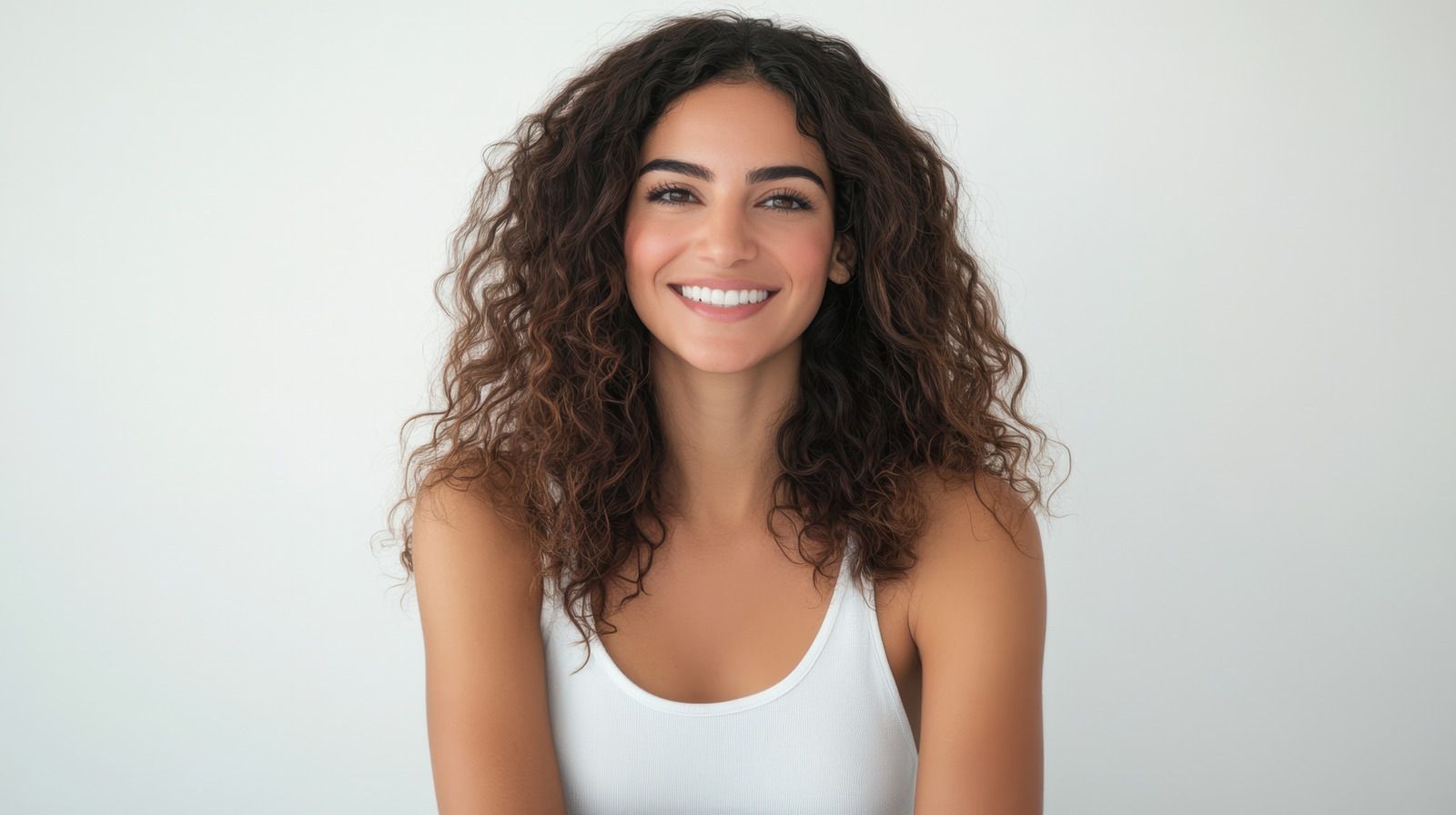 Woman with a white towel on her head, smiling.