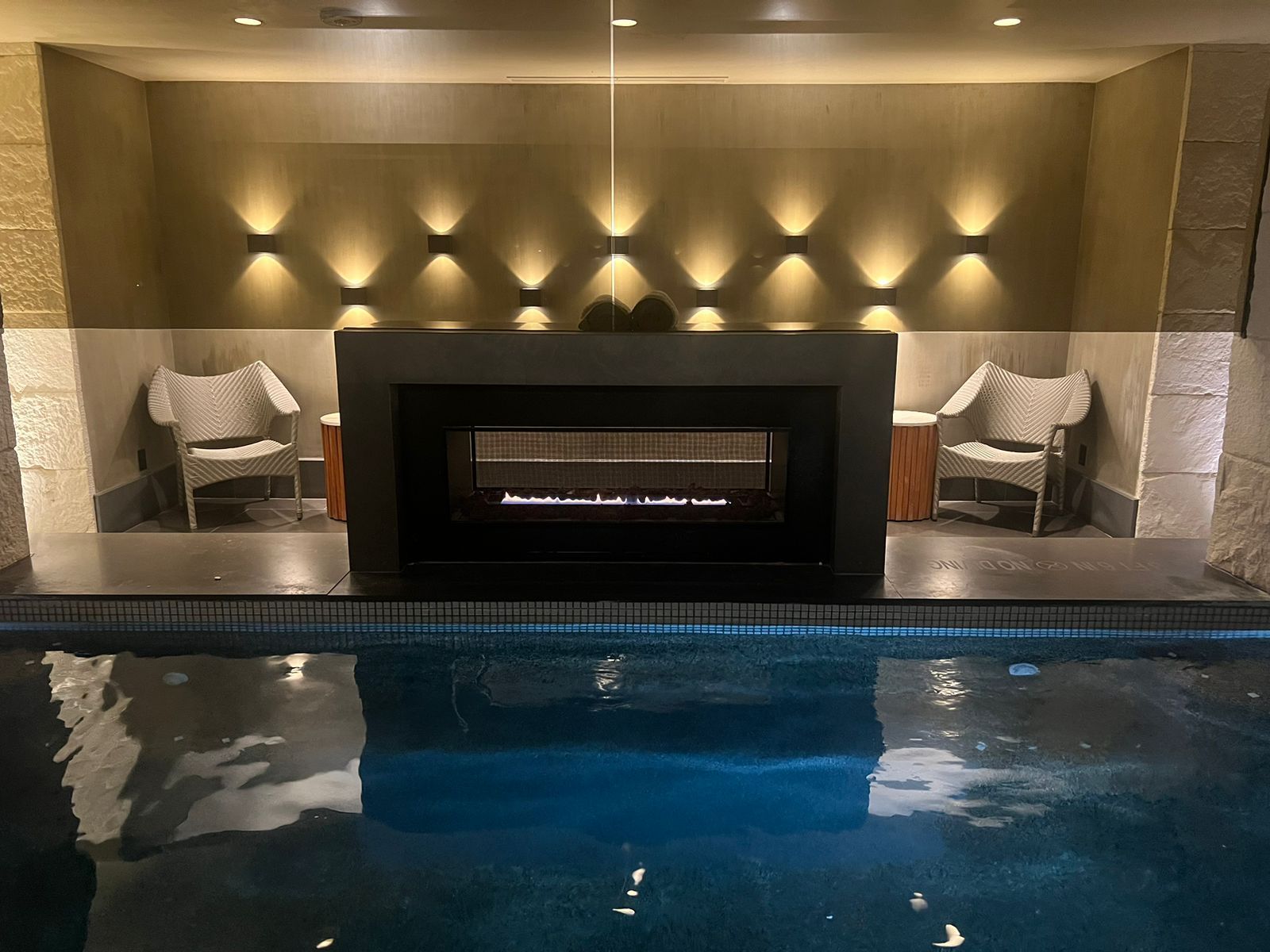 There is a fireplace in the middle of a swimming pool.