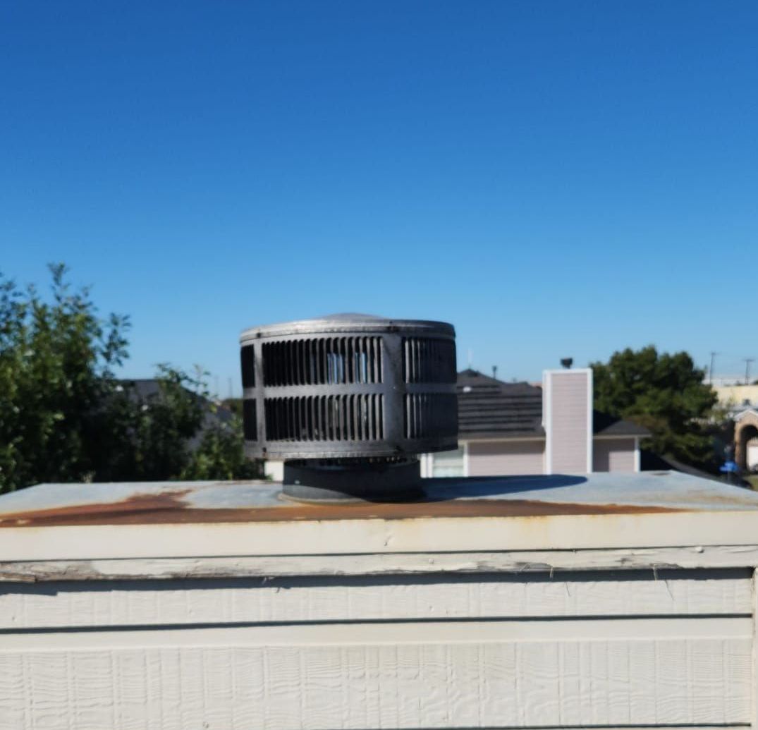 A chimney on top of a building with a blue sky in the background