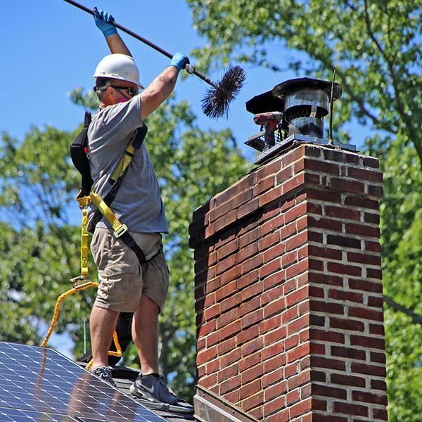 a man is cleaning a chimney with a brush