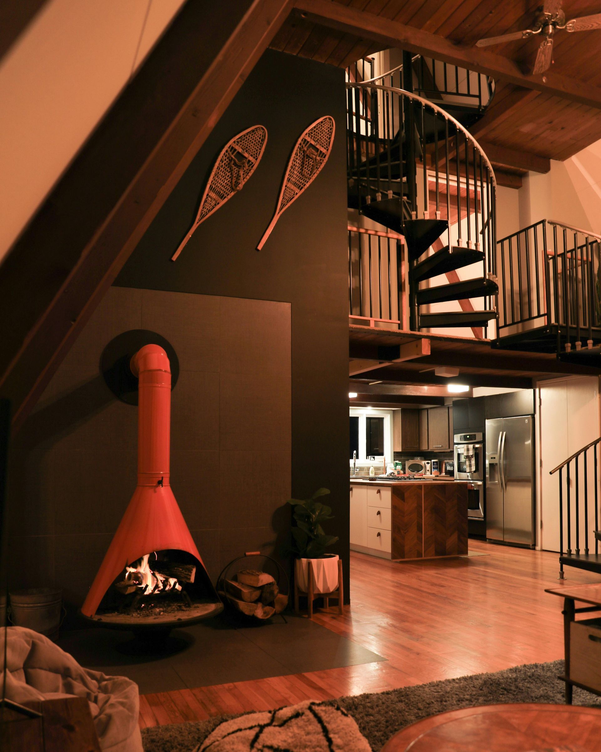 A living room with a fireplace and a spiral staircase