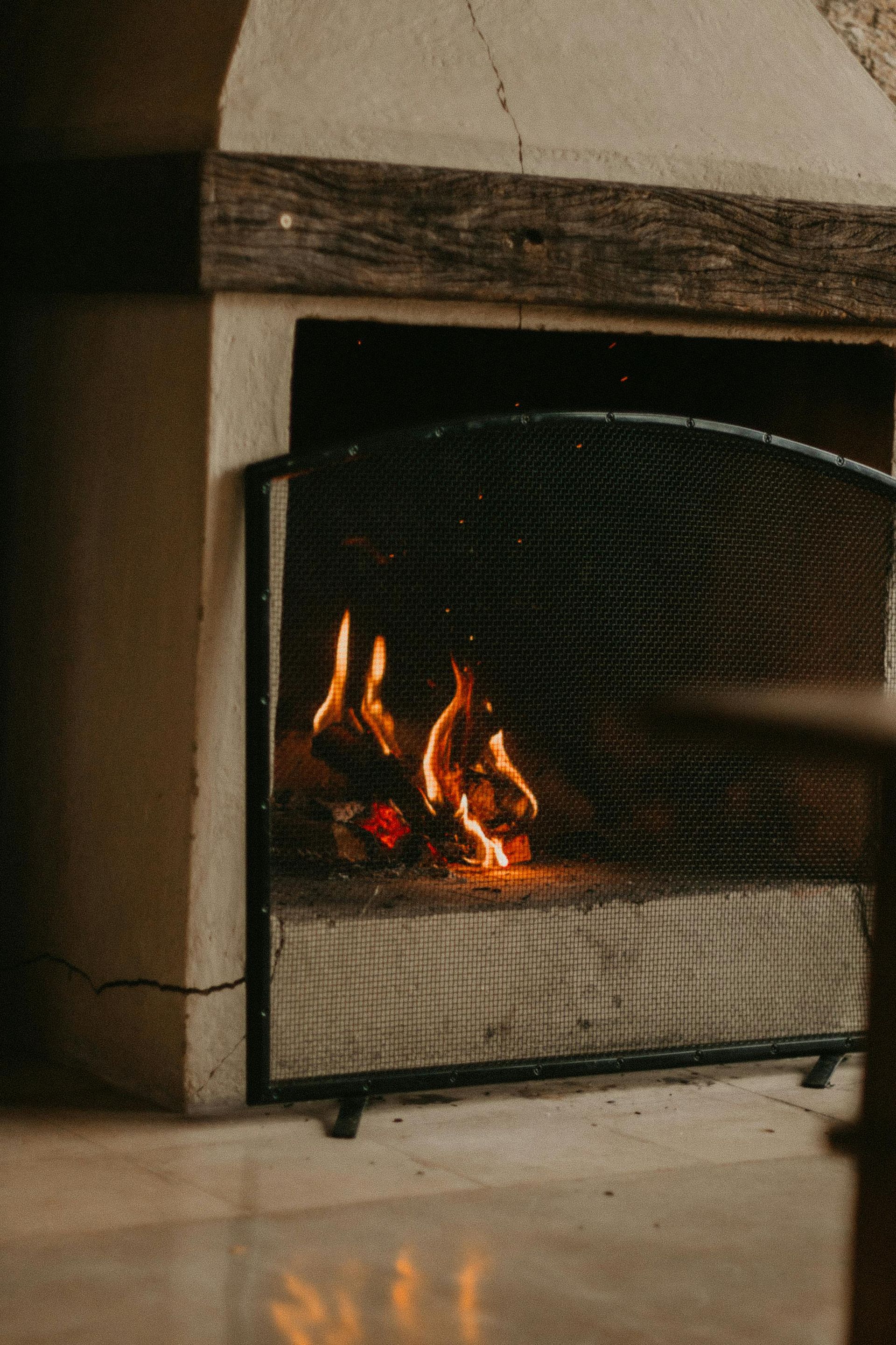 A fireplace with a fire in it and a fire screen.