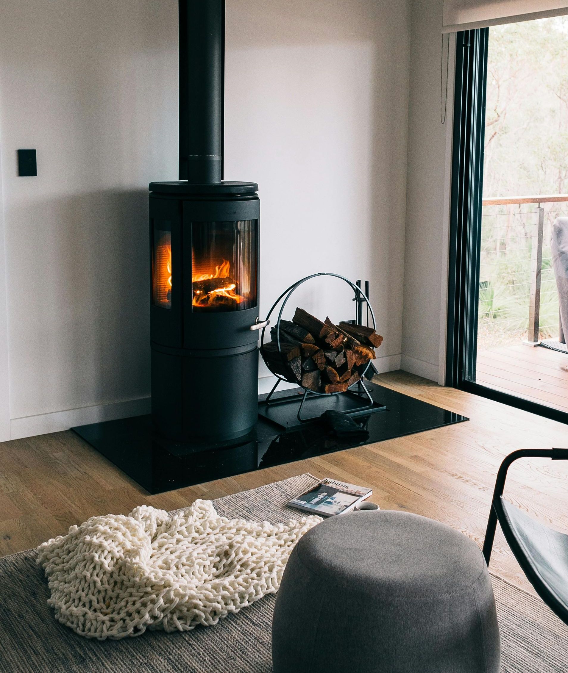 A living room with a fireplace and a blanket on the floor