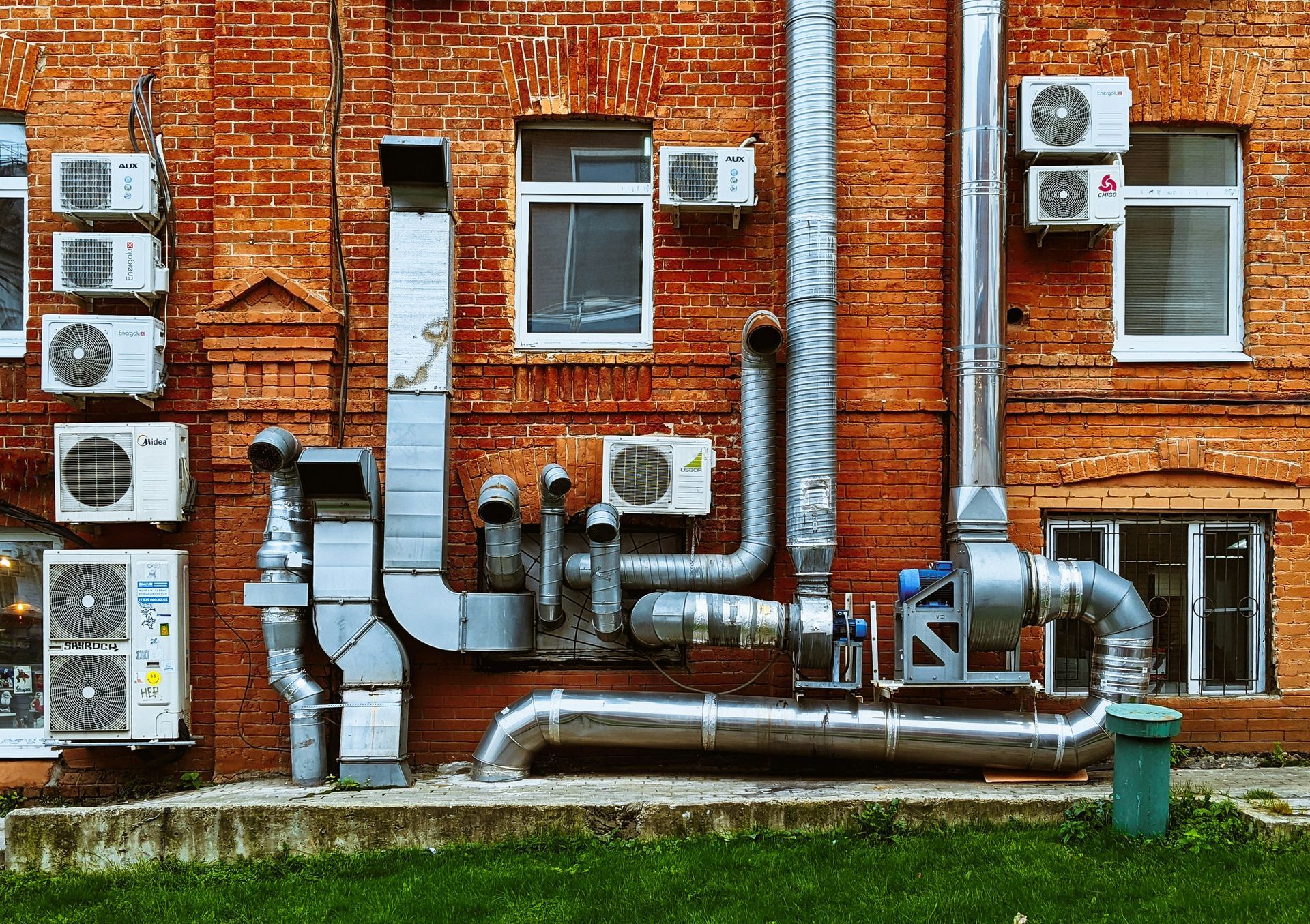 A brick building with a lot of pipes and air conditioners on it