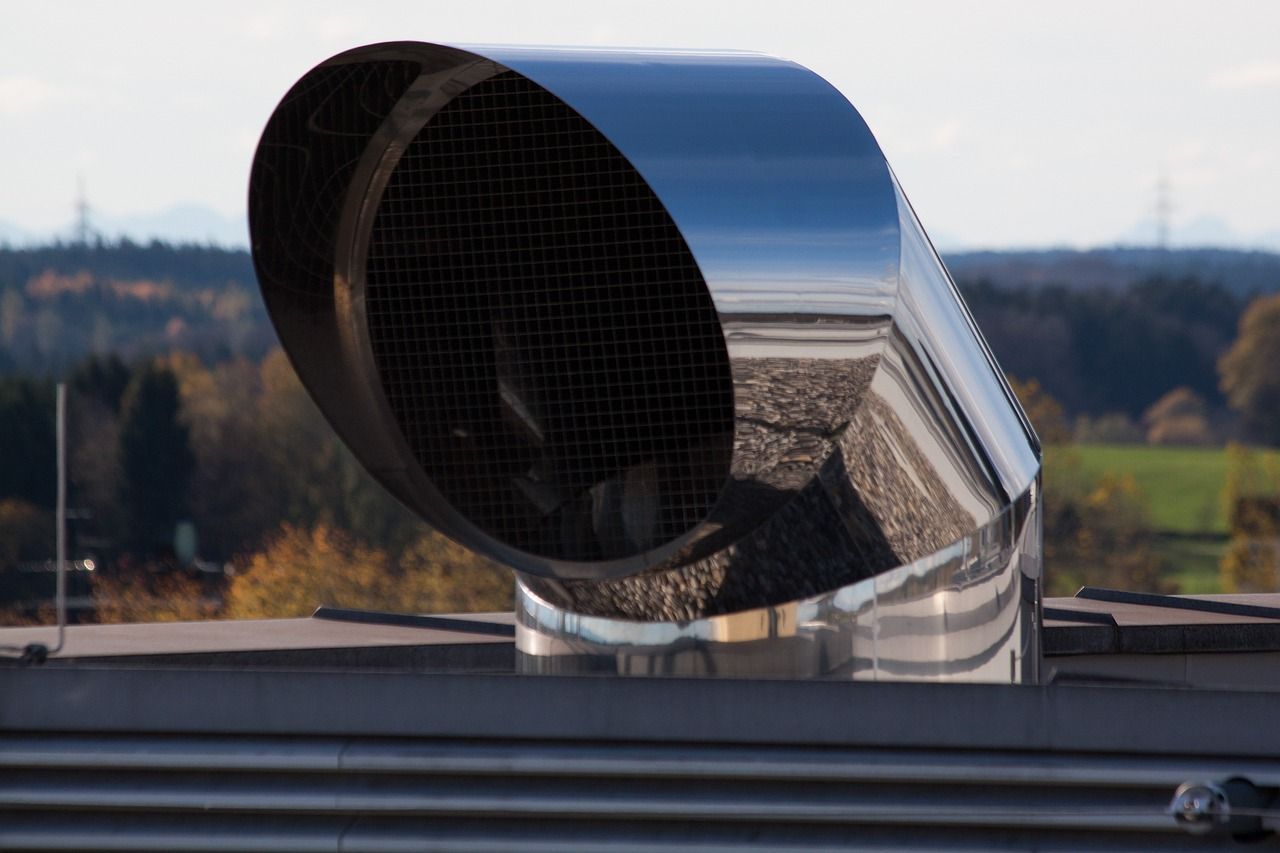 A stainless steel exhaust pipe on top of a building