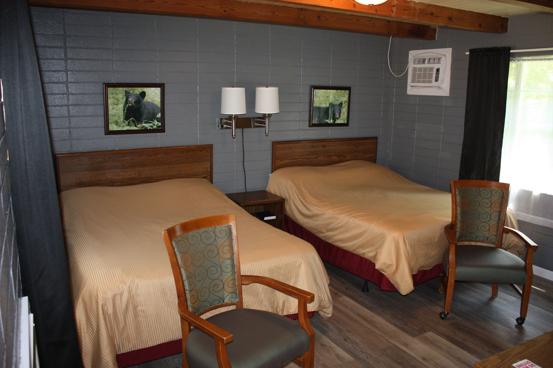 A hotel room with two beds and two chairs