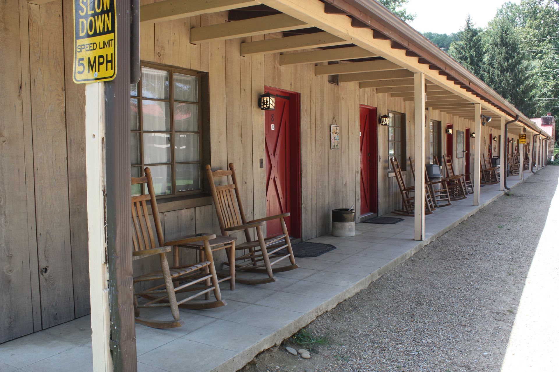 A motel with rocking chairs and a sign that says 5 mph
