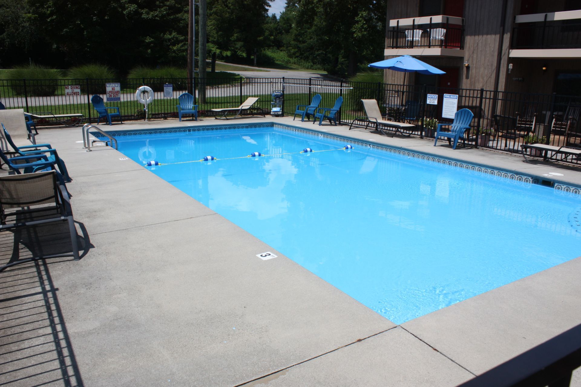 A large swimming pool surrounded by chairs and umbrellas