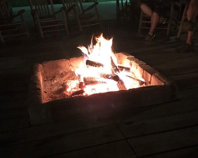 People are sitting around a fire pit at night