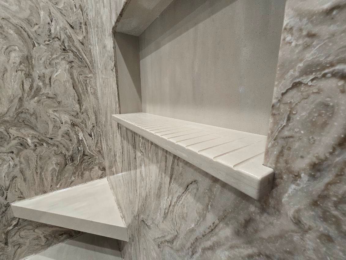 A bathroom with a shower shelf in the wall.