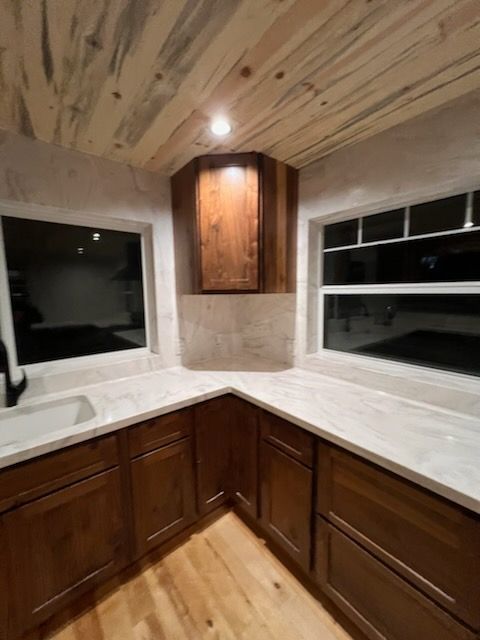 A kitchen with wooden cabinets and white counter tops