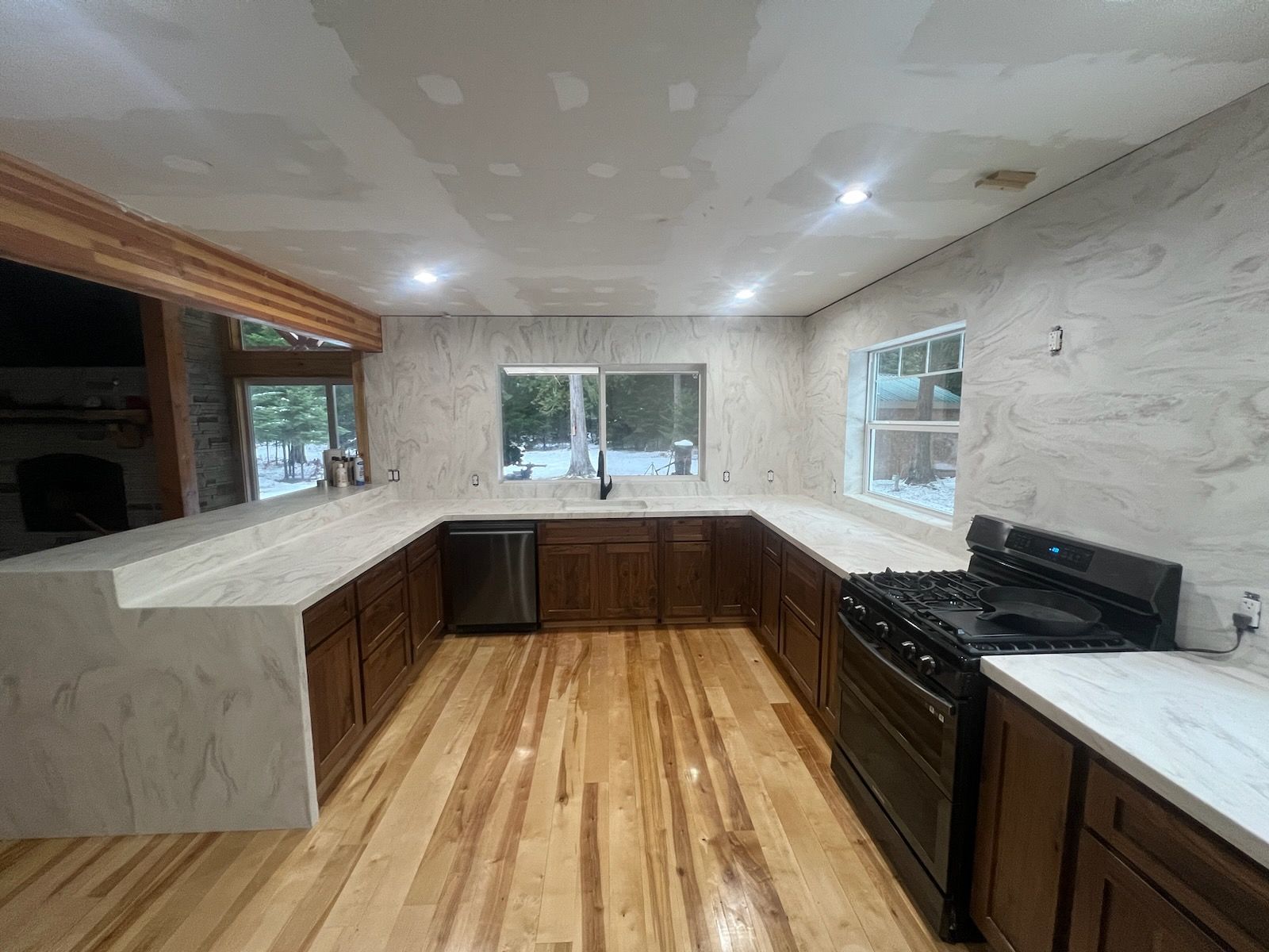 A kitchen with wooden cabinets , a stove , and a sink.