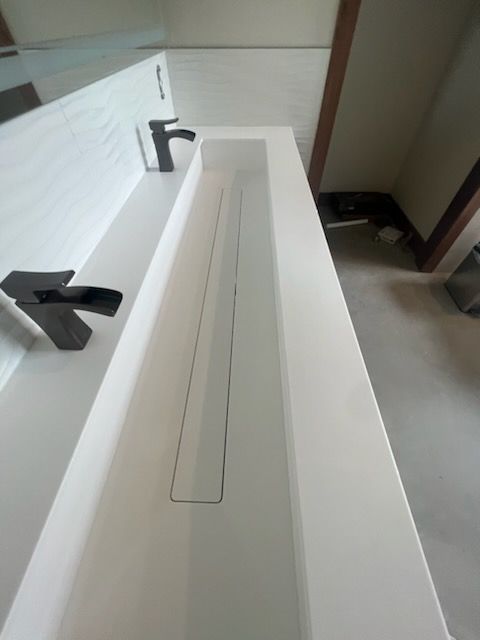 A bathroom sink with a black faucet and drain