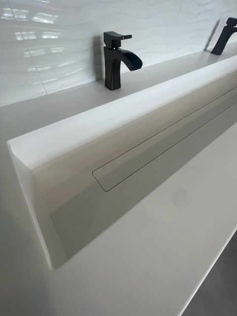 A bathroom sink with two black faucets on it