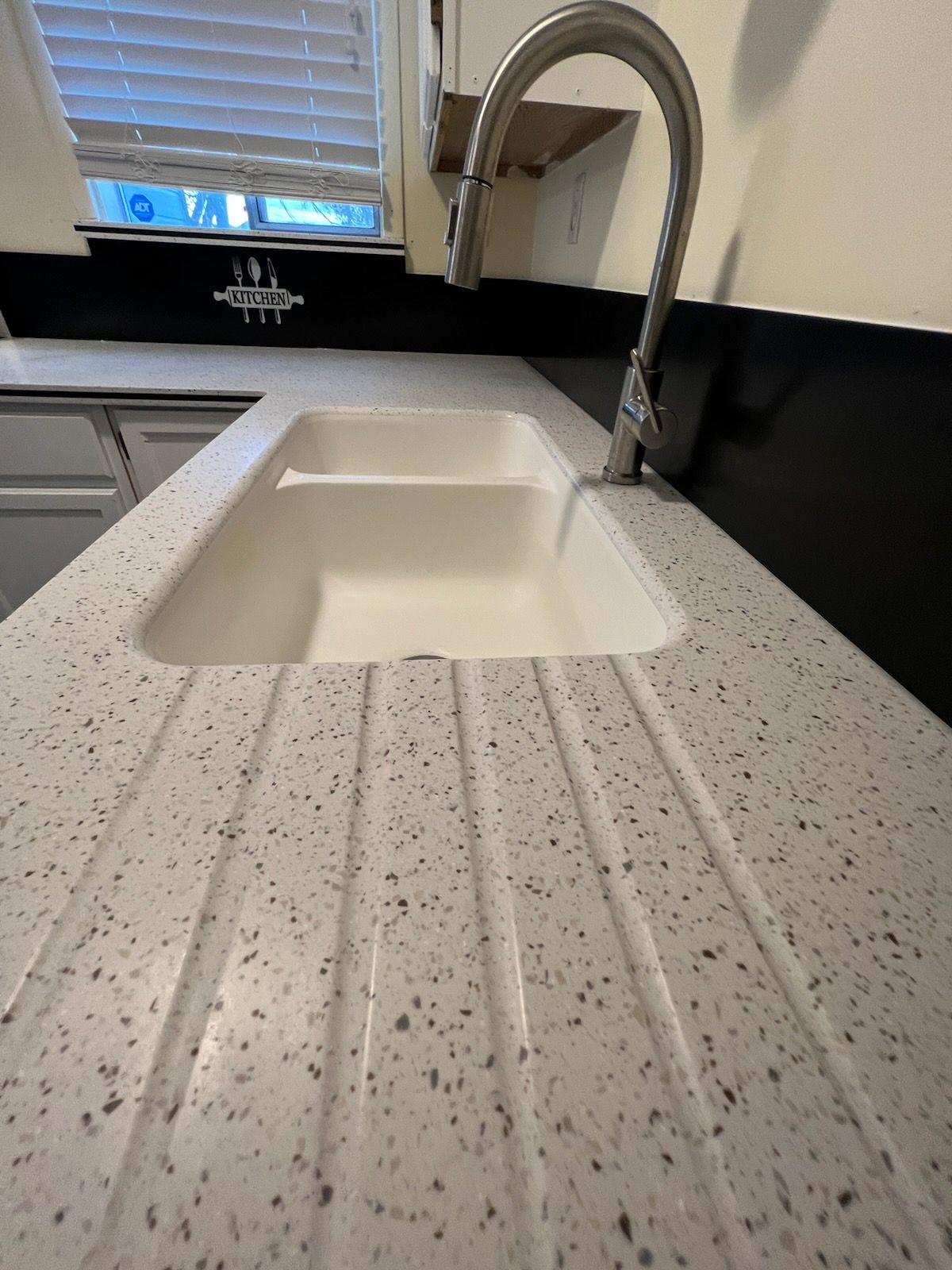 A kitchen sink with a faucet on a counter top