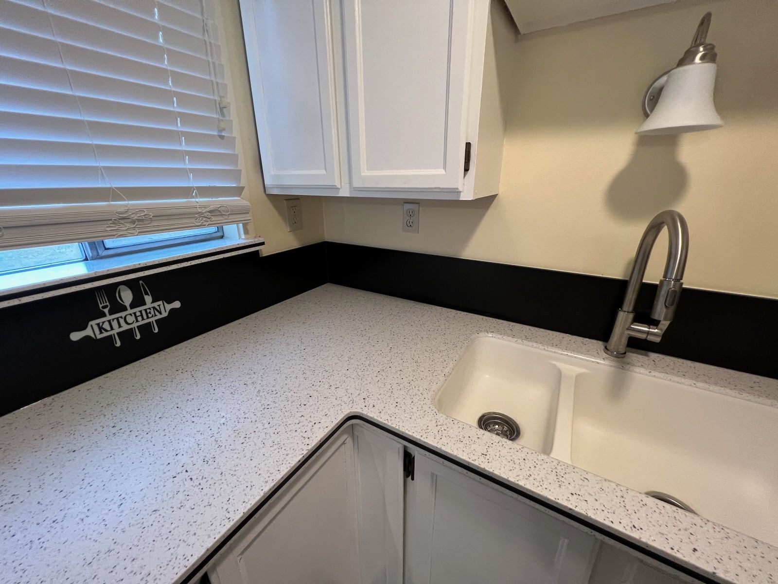 A kitchen with a sink and a sign that says kitchen