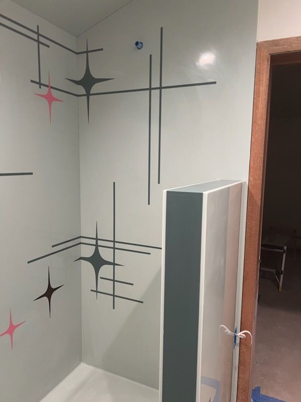 A bathroom with a shower stall and a door