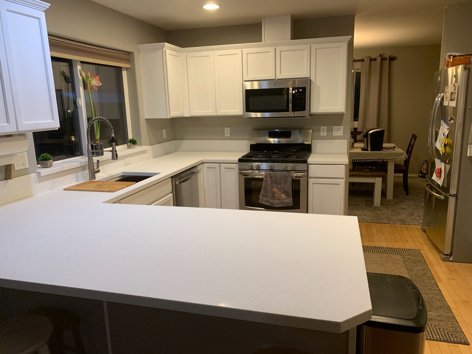 A kitchen with white cabinets and stainless steel appliances.