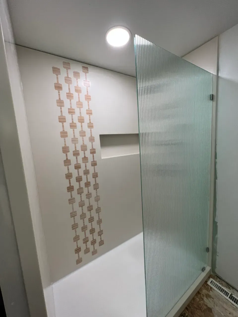 A bathroom with a walk in shower and a sliding glass door.