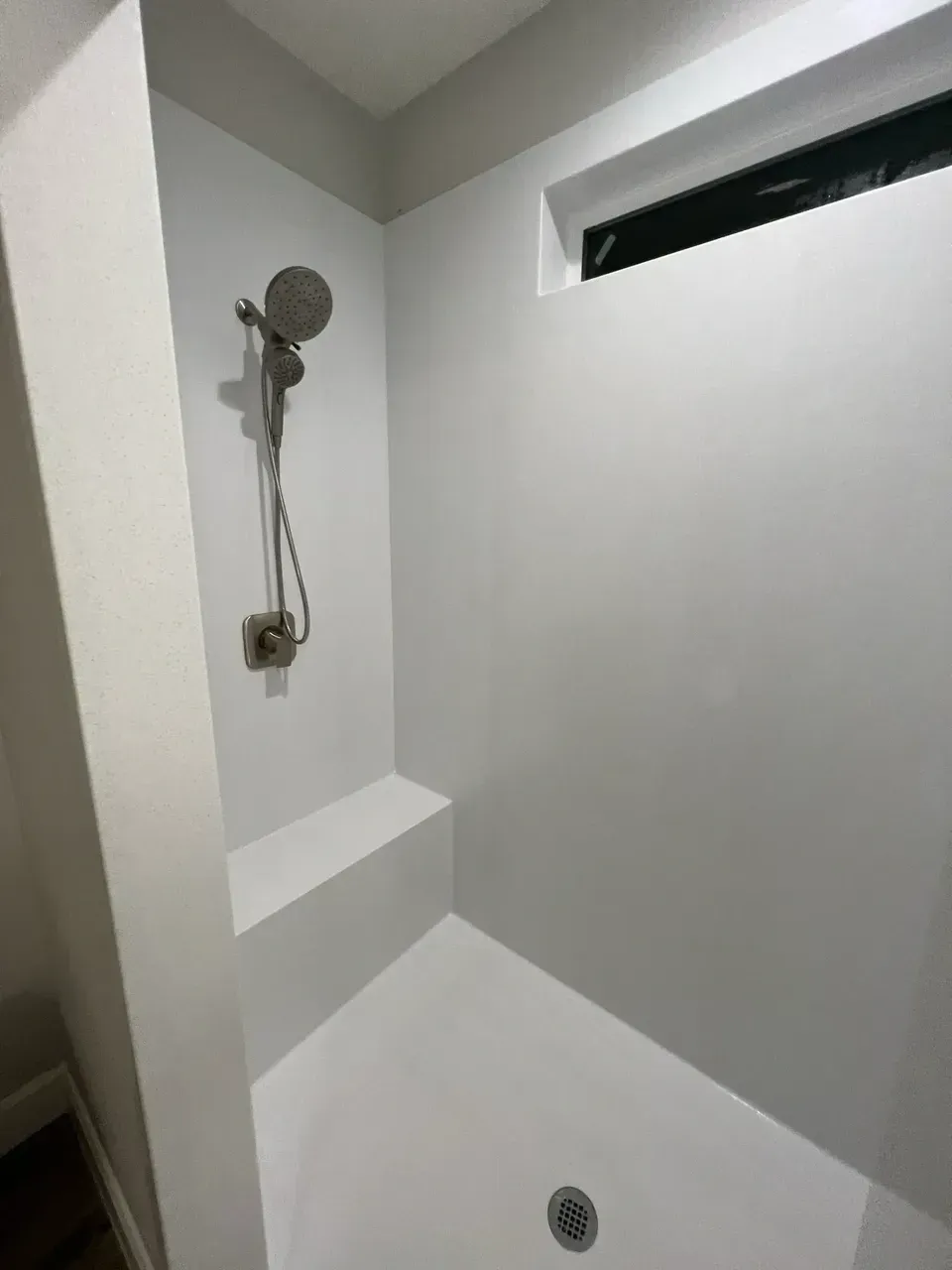A shower with a window and a shower head