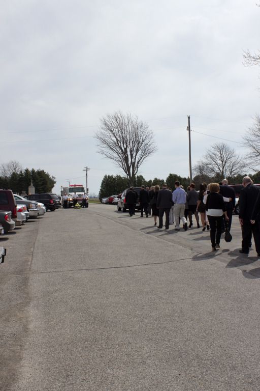 a group of people are walking down a street with an ambulance in the background