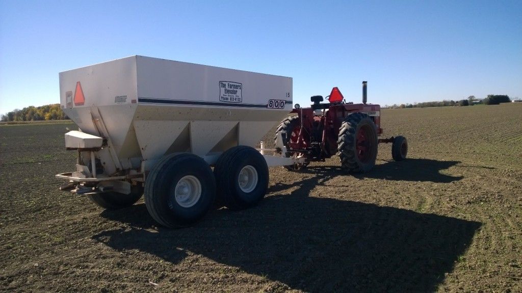 a tractor with a fertilizer spreader attached to it