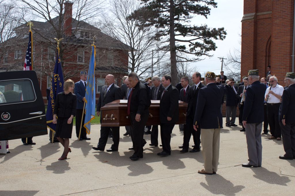 a group of people carrying a coffin with the number 9 on it