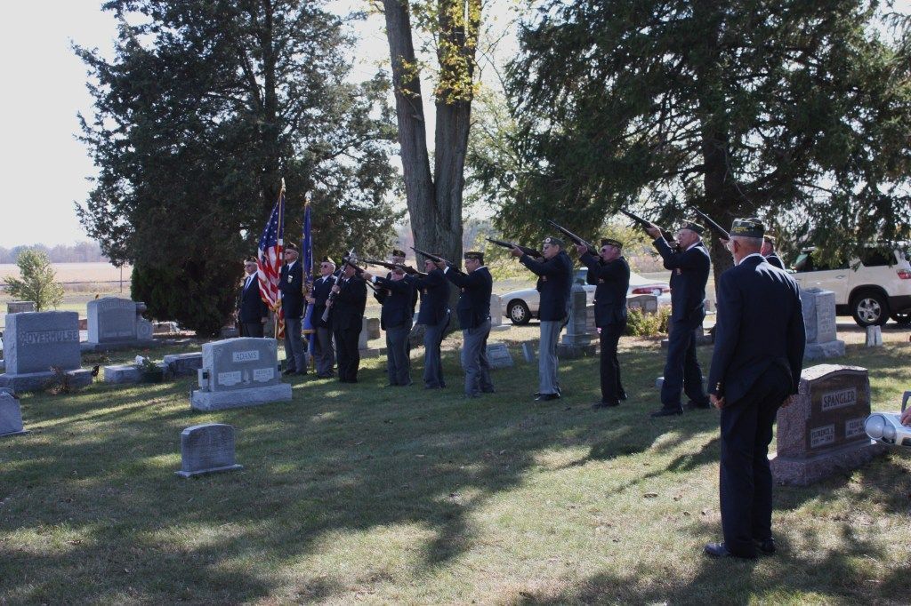 a group of soldiers stand in front of a cemetery with a grave that says ' johnson ' on it
