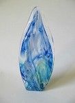 a blue and white glass sculpture is sitting on a white table .