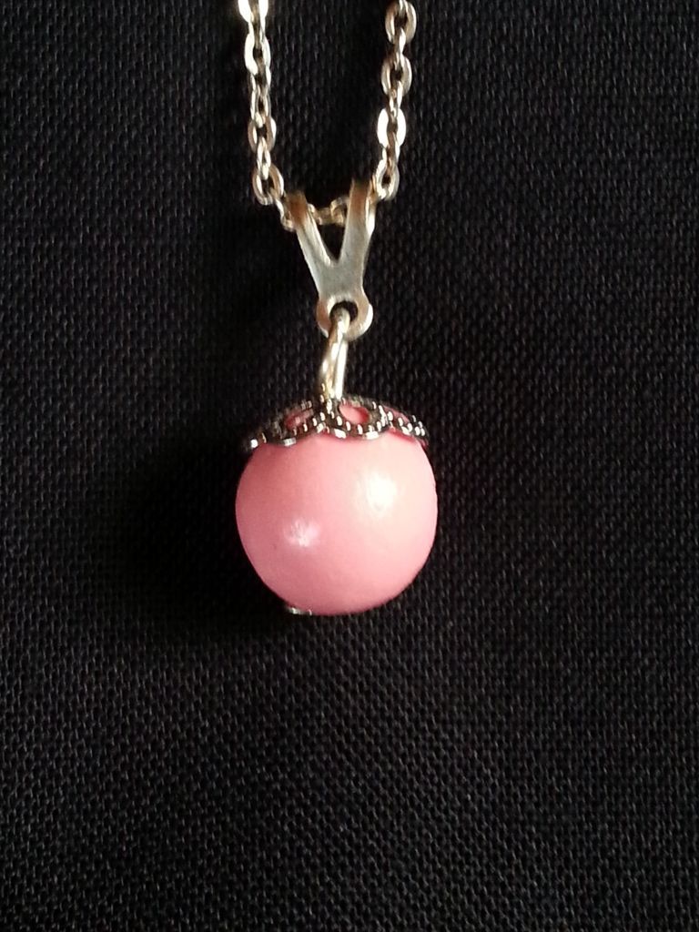 a necklace with a pink pendant on a silver chain