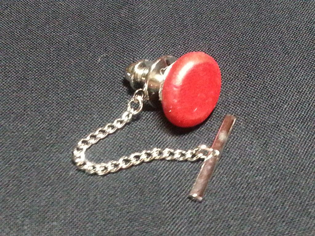 a red button with a silver chain attached to it