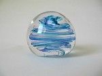 a blue glass paperweight is sitting on a white surface .