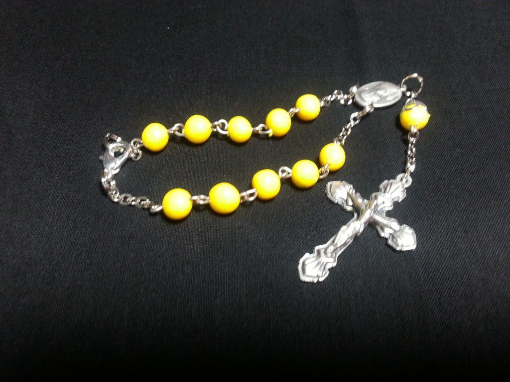 a rosary with yellow beads and a silver cross