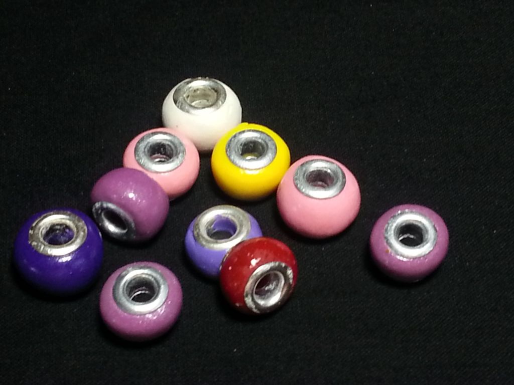 a bunch of different colored beads with silver rings on them