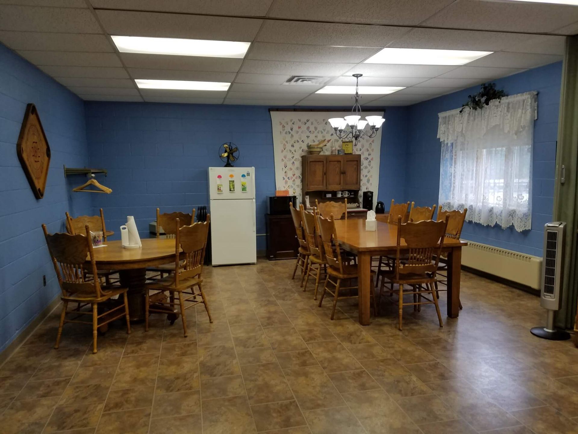a dining room with a table and chairs and a refrigerator