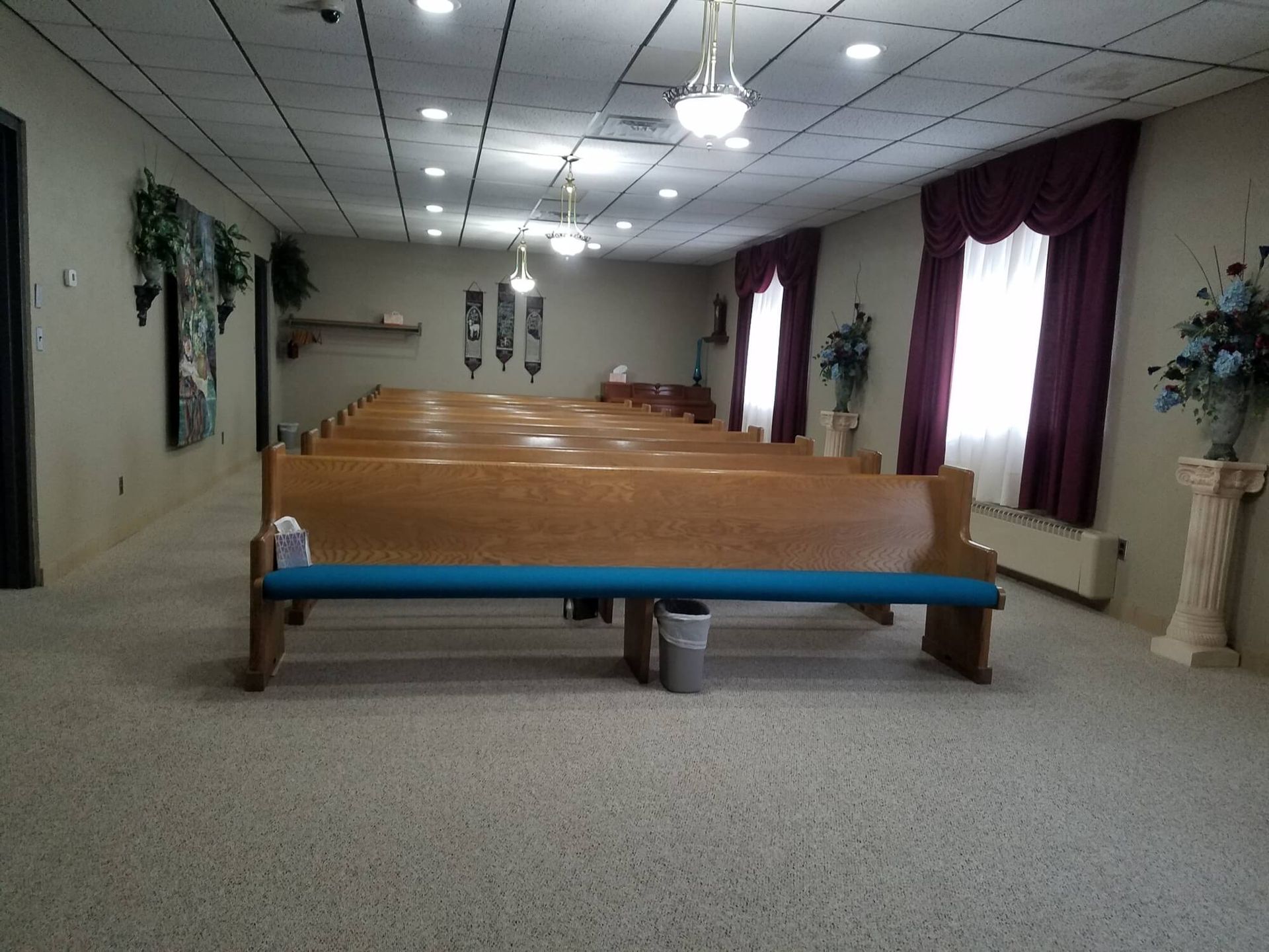 an empty church with wooden benches and purple curtains