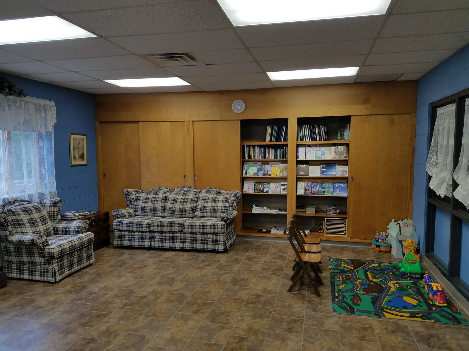 a living room with a couch and chairs and bookshelves