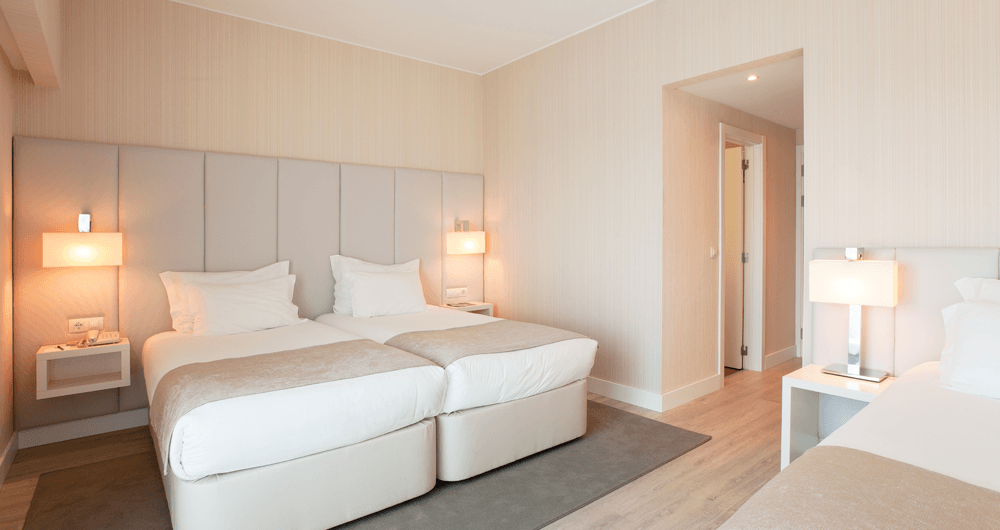 Um quarto de hotel com duas camas e um sofá.