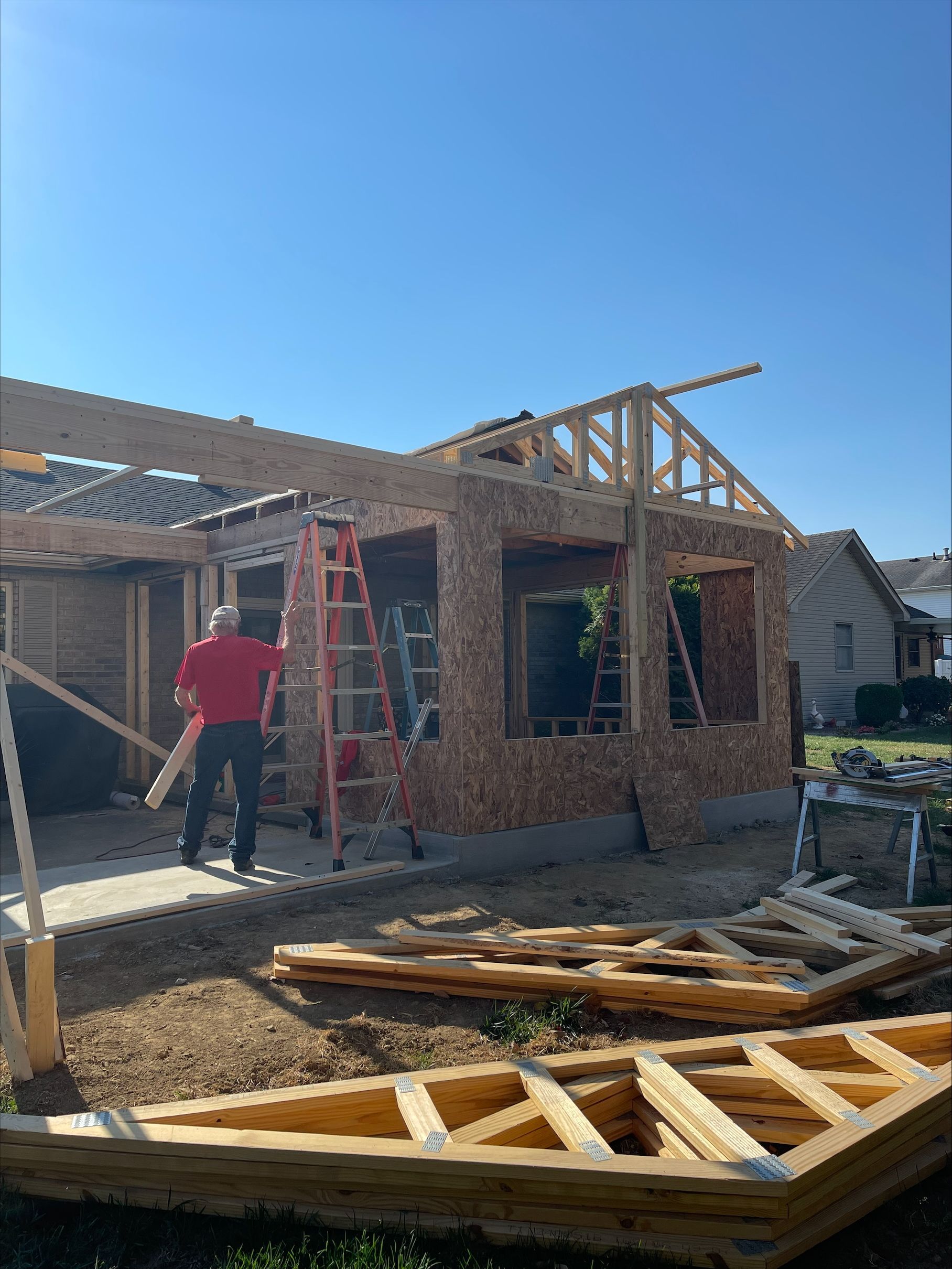 A man is standing in front of a house under construction.