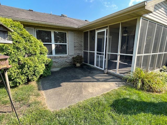 There is a screened in porch in the backyard of a house.