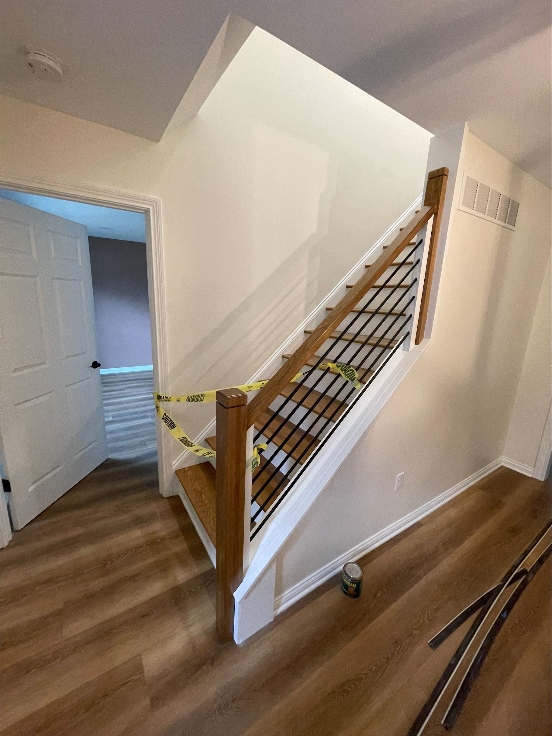 A staircase with a wooden railing is being built in a house.