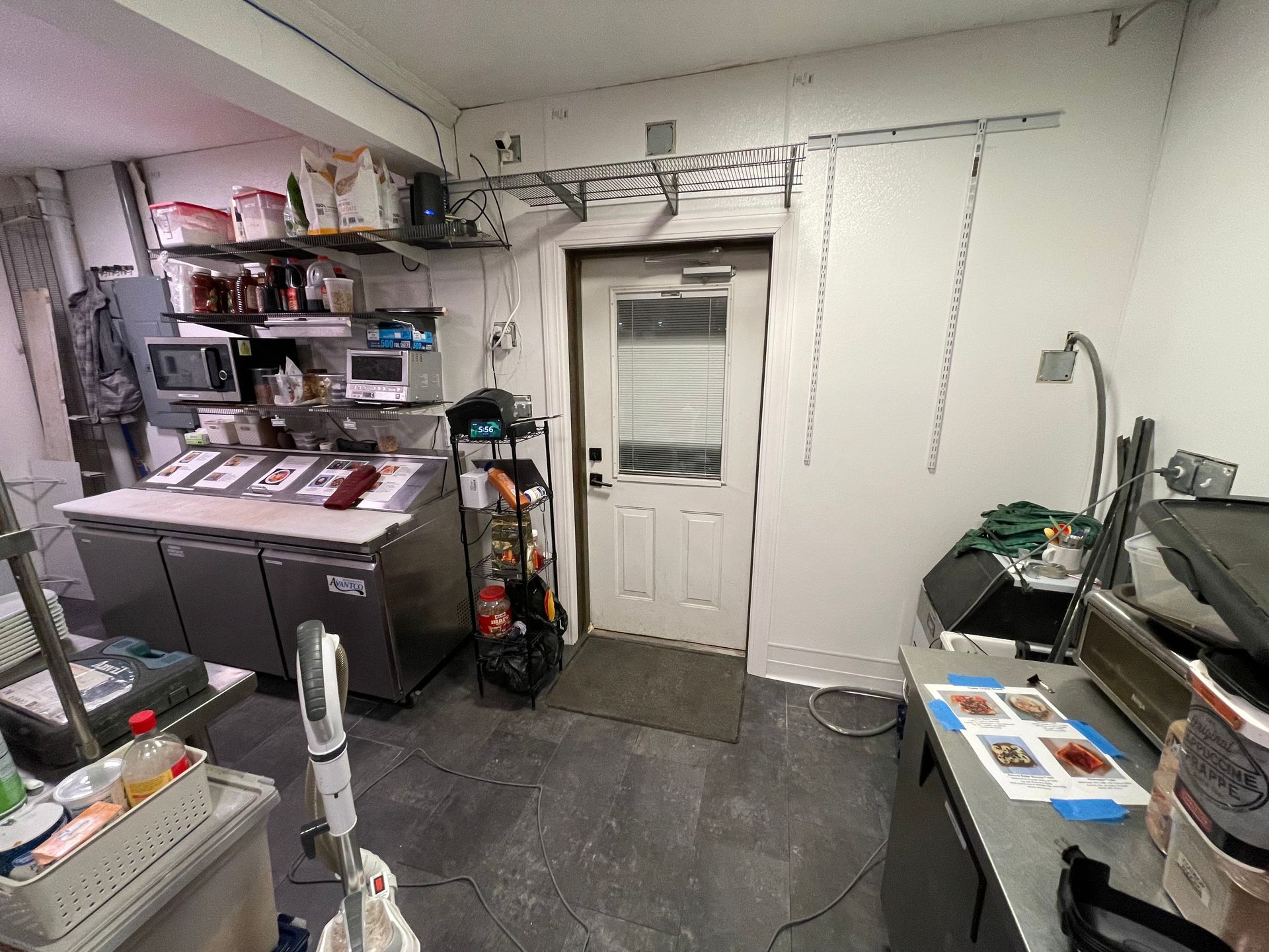 A kitchen with a lot of appliances and a door.