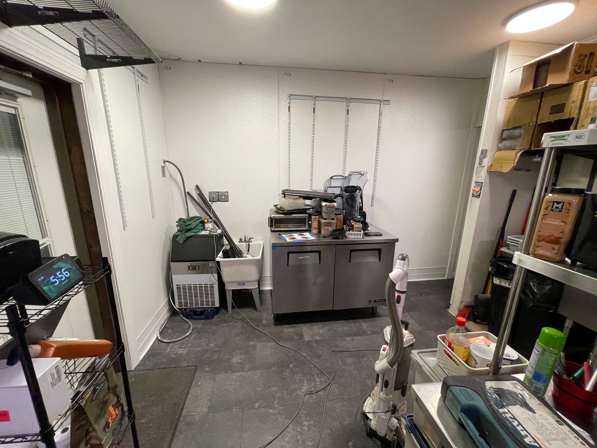 A room with a sink and a vacuum cleaner in it.