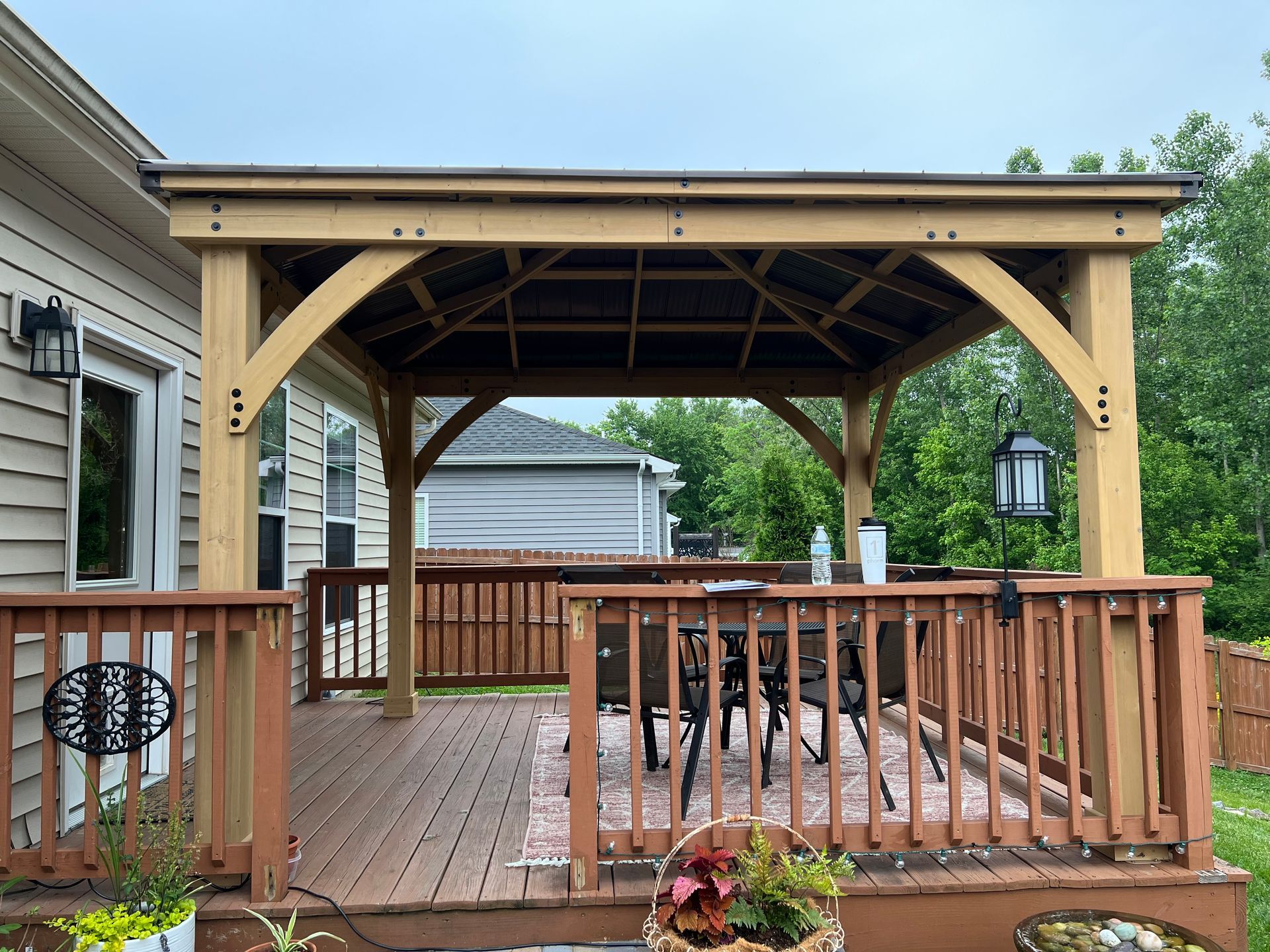 A wooden gazebo is sitting on top of a wooden deck.