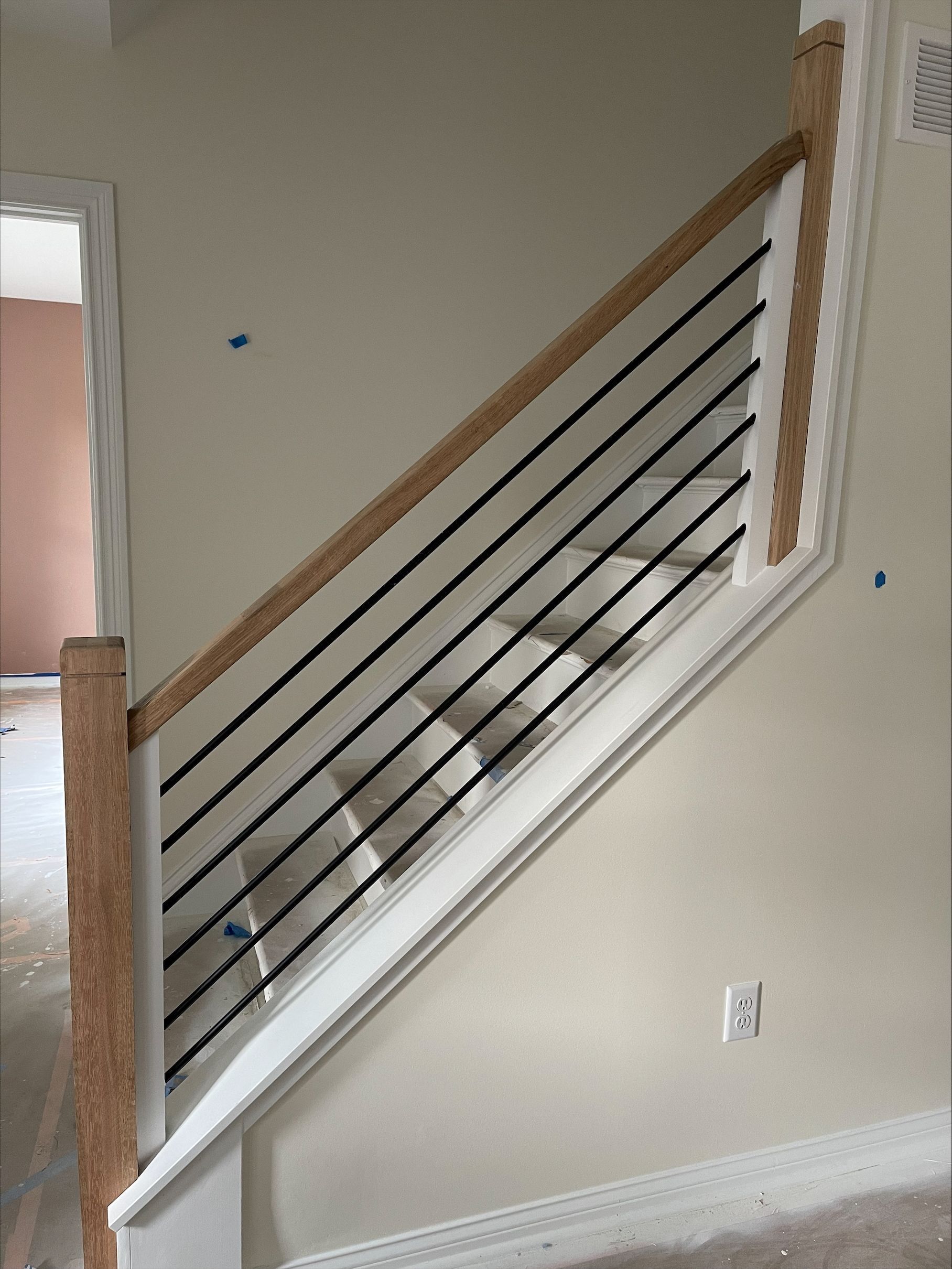 A white staircase with a black railing in a room.