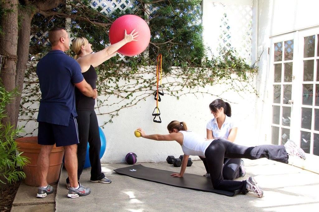 A group of people are doing exercises on a patio