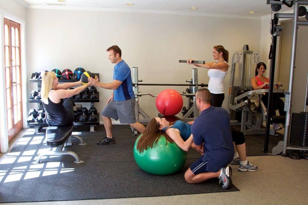 A group of people are doing exercises in a gym
