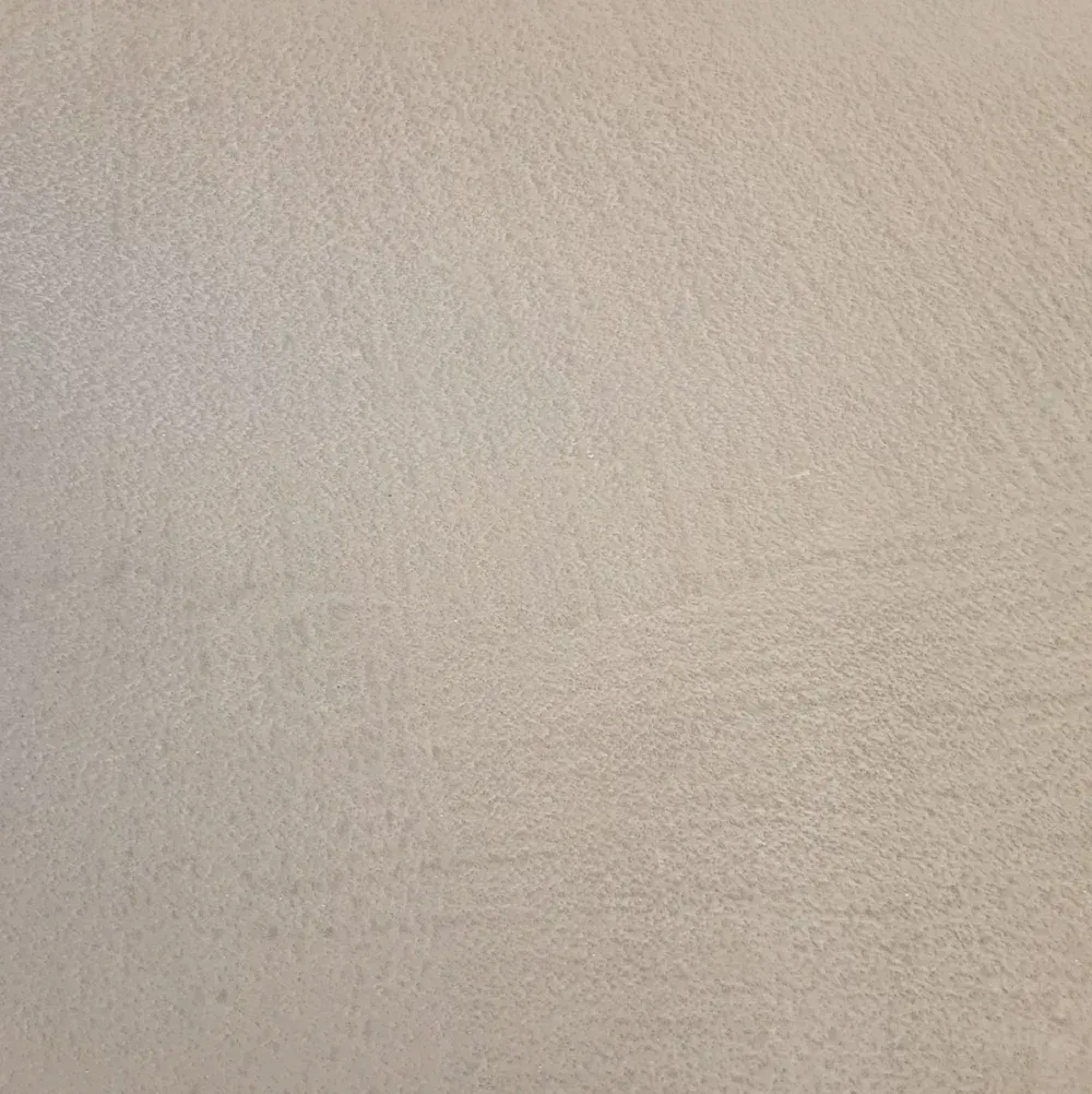 Close-up of a beige textured wall surface with subtle shadows