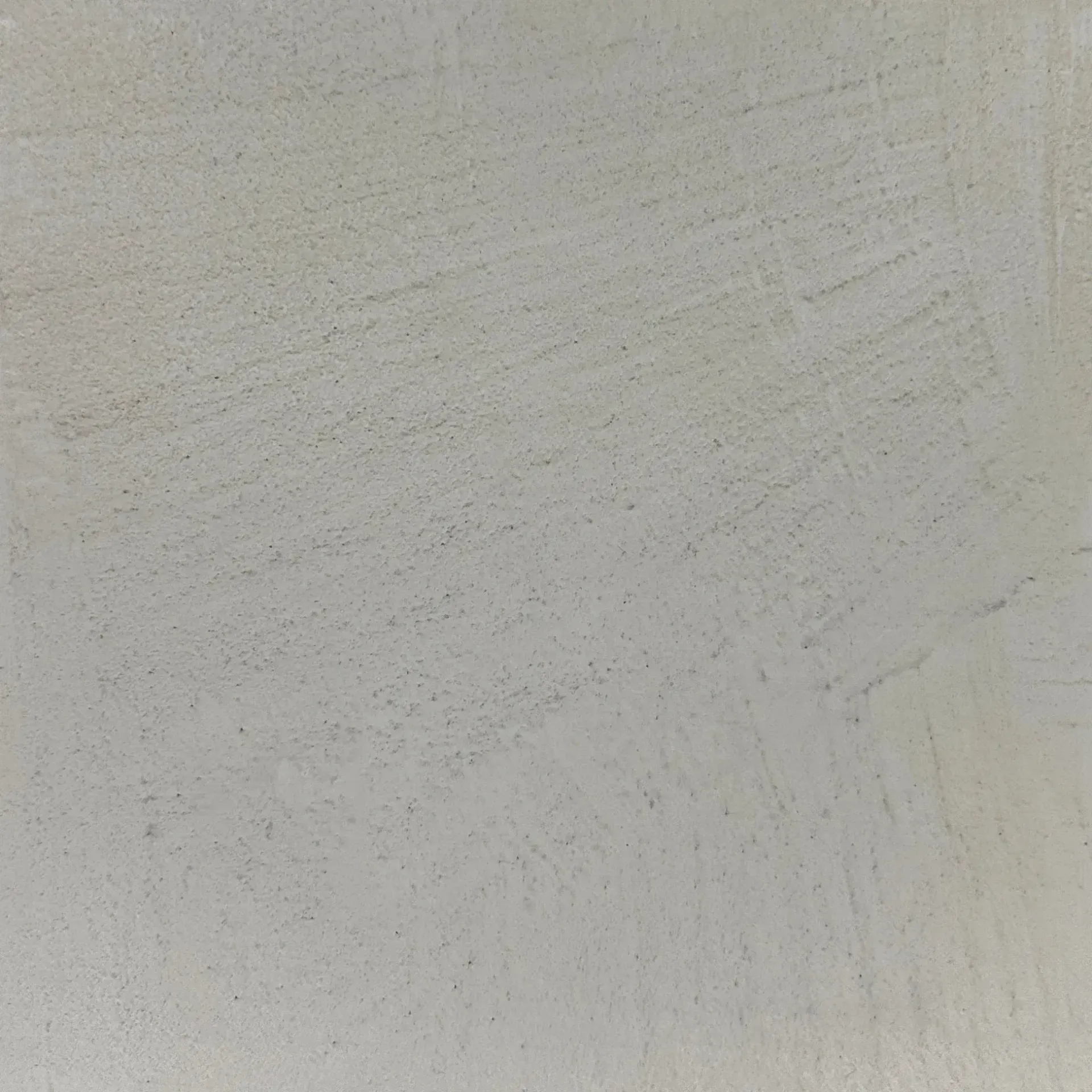 Close-up of a textured off-white wall with subtle gray streaks and speckled marks
