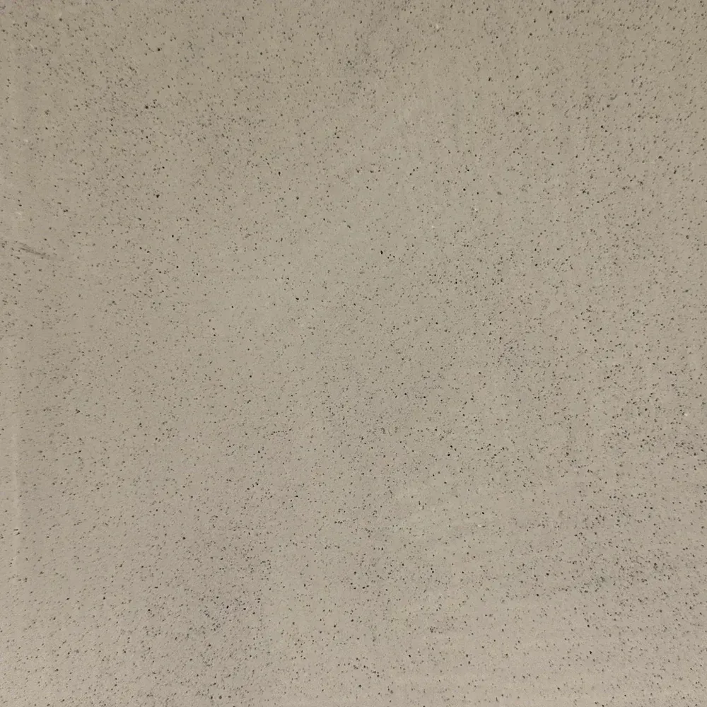 Close-up of a speckled beige textured surface with small dark flecks